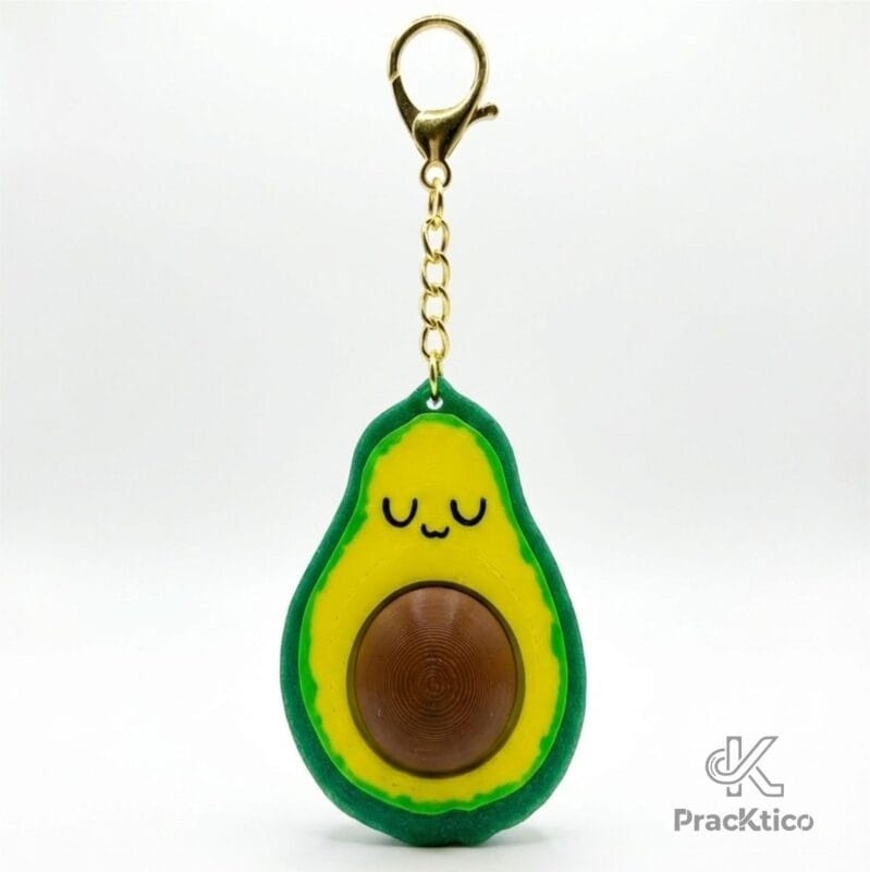 Vista frontal de llavero con forma de aguacate estilo kawaii con semilla marrón y cadena dorada sobre fondo blanco.