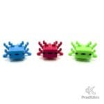 Tres figuras de ajolotes pixelados en colores azul, rosa y verde lima alineados de frente sobre fondo blanco.