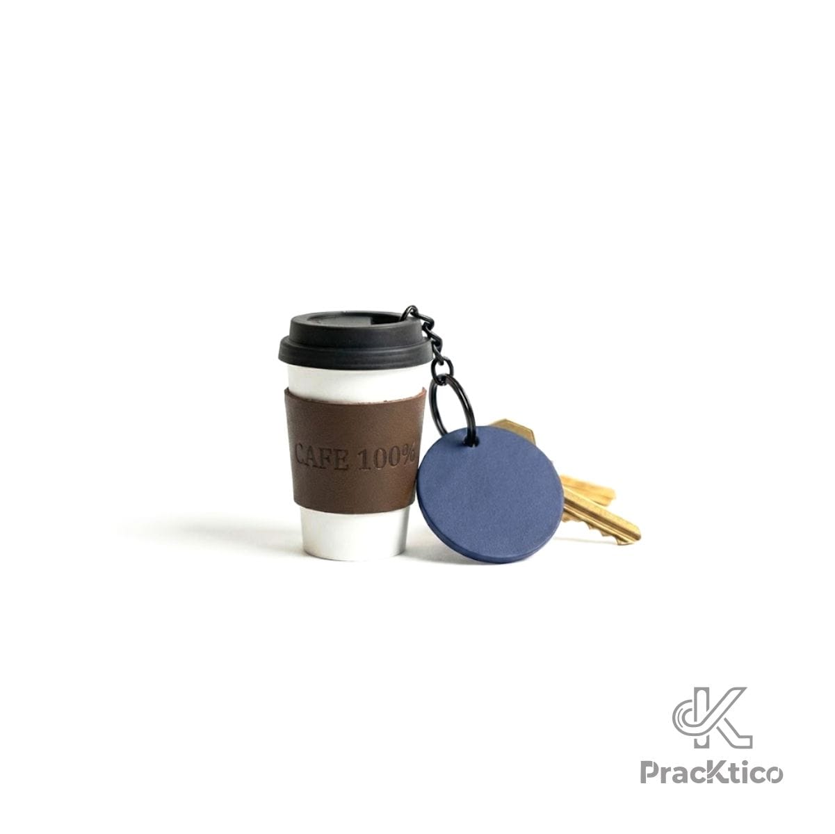 Detalle de llavero forma de café con etiqueta azul redonda y llaves doradas.