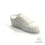 Pisapapeles magnético color blanco modelo zapatilla clásica sobre superficie blanca.