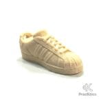 Miniatura de tenis color beige o crema estilo vintage para decoración de escritorio.